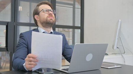 Multi Tasking Young Businessman Shocked by Fail Contractの写真素材
