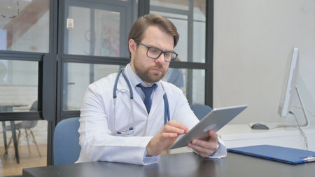 Mature Adult Doctor Using Digital Tablet in Hospitalの写真素材