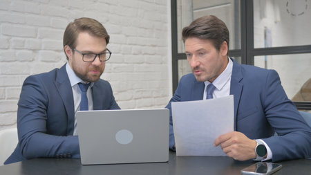 Business People Doing Paperwork Together in Officeの写真素材