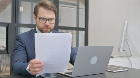 Young Businessman Doing Paperwork at Workの写真素材