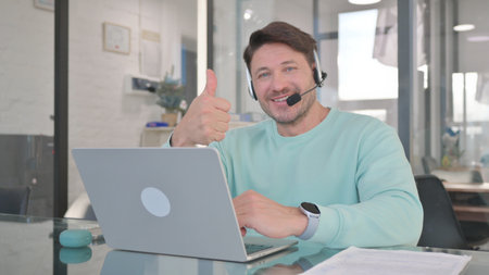 Thumbs Up by Man in Call Center with Headsetの写真素材