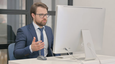 Online Video Chat by Young Businessman on Computerの写真素材