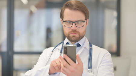 Portrait of Doctor Using Smartphone, Browsing Internetの写真素材