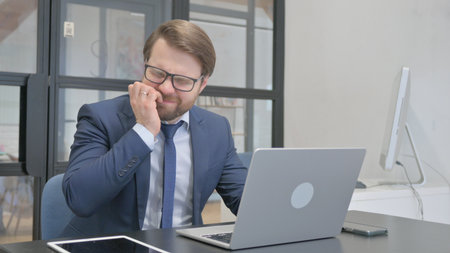 Businessman with Toothache feeling Uncomfortable at Workの写真素材