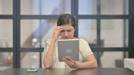 Young Indian Woman with Loss on Tabletの写真素材