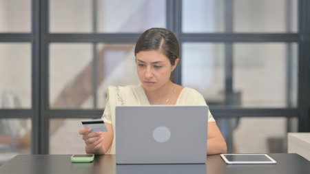 Young Indian Woman Enjoying Online Shopping via Laptopの写真素材