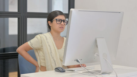 Young Indian Woman with Spinal Injury Working on Desktopの写真素材