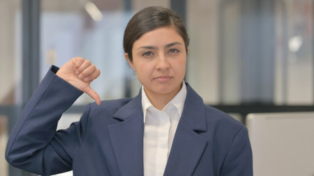 Criticizing Indian Businesswoman with Thumbs Downの写真素材