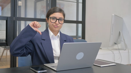Thumbs Down by Indian Businesswoman Using Laptop
