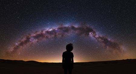 Silhouette of a boy looking at the milky way in the desertの素材