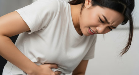 young asian woman suffering from backache at home, healthcare conceptの素材