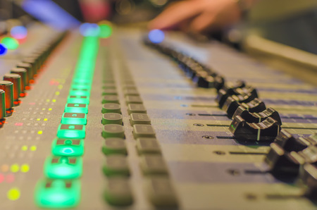 Blurred Hand on a mixer, operating the leader. Night concert scene. Wide angle, shallow deept of fieldの写真素材