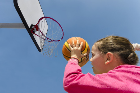 beautifull girl shooting basket and playing basketball, lower view wide angleの写真素材