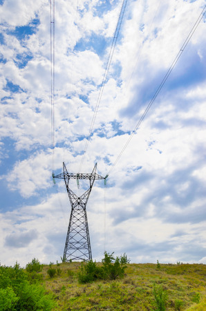 Electricity pylon against blue cloudy skyの写真素材