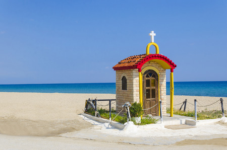small colorful church on the beach seaside sand and clear blue water and skyの写真素材