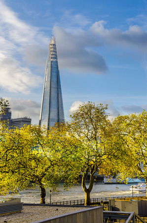 New London skyline and the Shard skyscraper with yellow autumn trees on Thames river with clear blue sky  verticalのeditorial素材