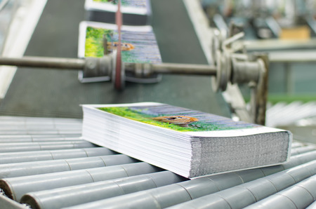 Book, magazine,  production line into press plant house. Automatic assembly line close up