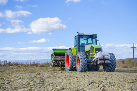 Ploughing heavy tractor during cultivation agriculture works at field with ploughの写真素材
