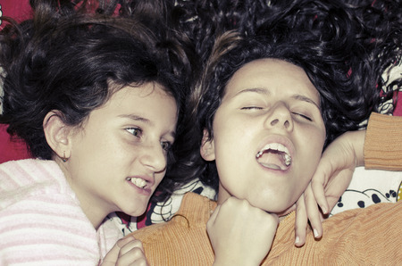 little sister girls fighting angry in bedの写真素材
