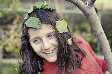 portrait of happy little cute girl is playing hide and seek in the parkの写真素材