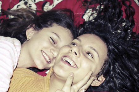 Happy smiling kids sharing their secrets and bad hugging and smilingの写真素材