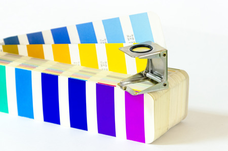 Magnifying glass standing on color guide on a white backgroundの写真素材