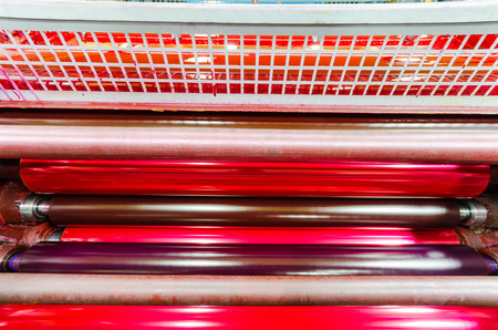 print machine printing press rollers, red magenda color drum, dramatic lightの写真素材
