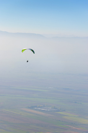Alone paraglider fly over valley aerial pov vertical compositionの写真素材