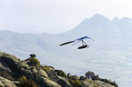 Glider silhouette take off high mountain rock. Extreme adrenaline sport flyの写真素材