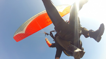 Tourist playing paragliding guided by a pilotの写真素材
