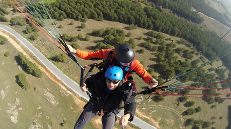 Tourist playing paragliding guided by a pilotの写真素材