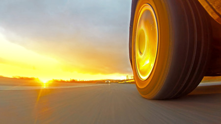 Driving a sport car on a country road at sunset. Wheel spinning POV - Point of View. Fast Speedの写真素材