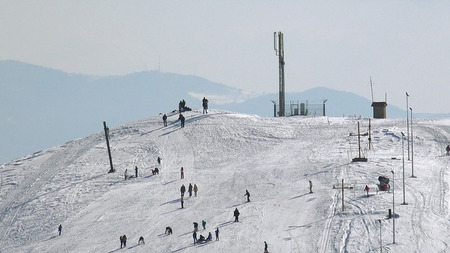 Skiers at the ski slope mountain top, snowy peaks of the Alpsの写真素材