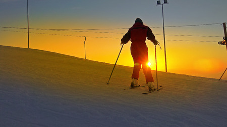 Ski Boots Being Attached To Carving Ski on sunset ski slopeの写真素材