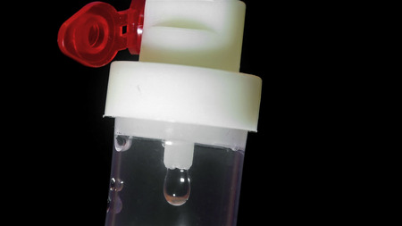 Saline drip extreme closeup on black backgroundの写真素材