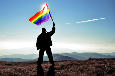 successfull silhouette man winner waving Argentinian flag on top of the mountain peakの写真素材