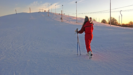Skier climbing a snowy mountain at sunsetの写真素材