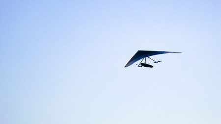 Glider silhouette flight over the cloudsの写真素材