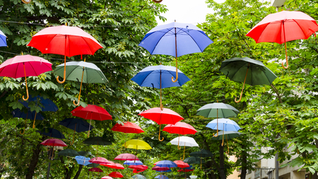 Street decorated with opened hanging colorful umbrellasの写真素材