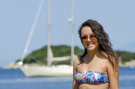 Boat woman smiling happy looking at the camera sailing by. Hispanic / Caucasian female model.の写真素材