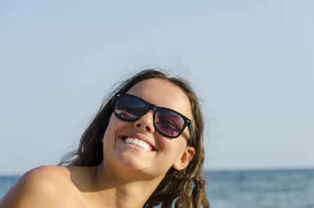 Happy girl Laughing. Closeup portrait woman smiling with perfect smile and white teeth looking up. Positive human emotion facial expression body language.の写真素材