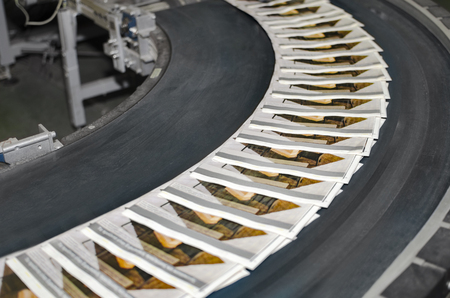 Working print machine with magazines on conveyor beltの写真素材