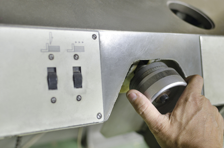 The industrial area, the mechanic hand adjusts the machineの写真素材