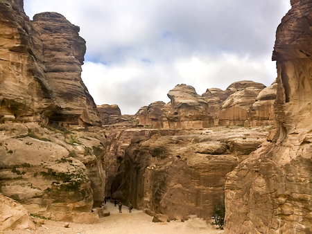The Siq, the narrow slot-canyon that serves as the entrance passage to the hidden city of Petra, Jordan, seen here with tourists walking.This is an UNESCO World Heritage Siteの写真素材