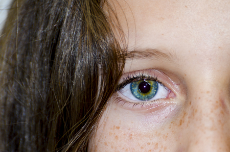 Beautiful green girl single eye close upの写真素材