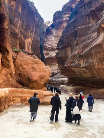 PETRA, JORDAN - circa DEC, 2016: Touris people on way through Siq gorge to stone city Petra, Jordanのeditorial素材