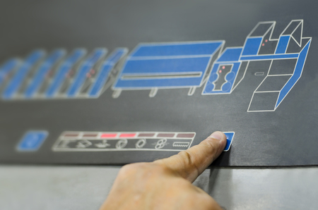 One finger pressing a print buttonon large offset printing machineの写真素材
