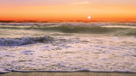 Waves at the beach at sunsetの写真素材