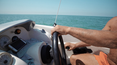 Hands of the skipper at the helm control of sailing boatの写真素材