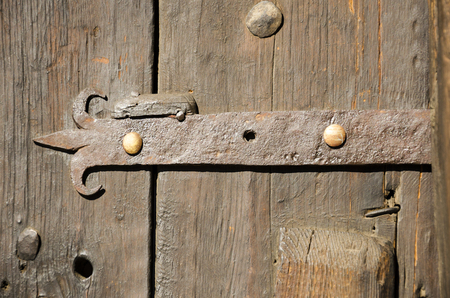 Old fashioned wooden door with metal hingeの写真素材